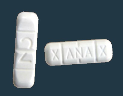 Billede af 2 Xanax-pille 2mg. Pillen er aflang med tre riller / delekærv på tværs, så de ligner en bar - enten sæbe eller chokolade-bar med tydelige opdelinger i felter.